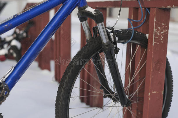 冬天，蓝色自行车锁在木制自行车架上