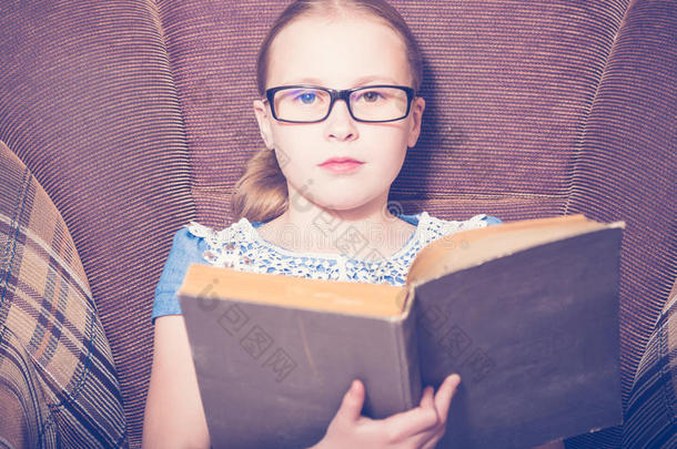 女孩在家看书，坐在扶手椅上