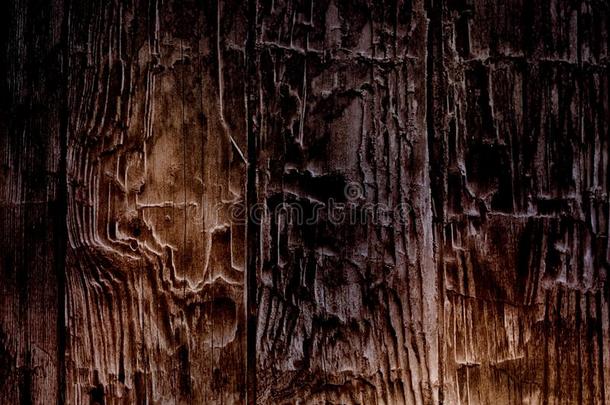 开裂的乡村深棕色木材纹理。 黑暗的顶部，从下面点燃。
