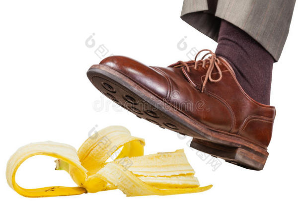 脚在左边棕色的鞋上滑在香蕉皮上