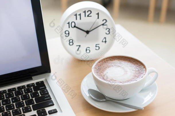 一杯白色杯子里的咖啡和桌子上的电脑桌面