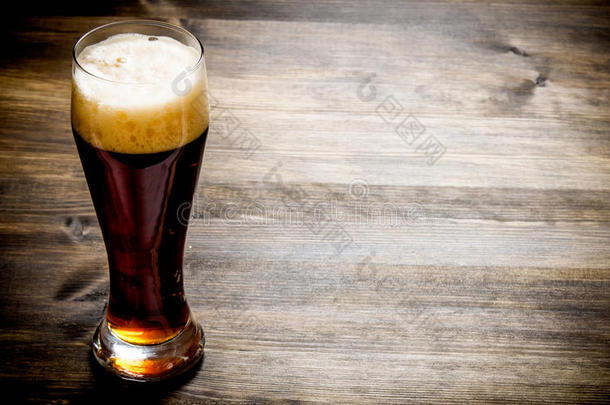 木制桌子上的一杯新<strong>鲜啤酒</strong>。