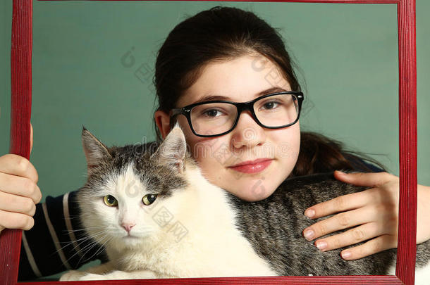 戴近视眼镜的女孩拥抱大西伯利亚猫