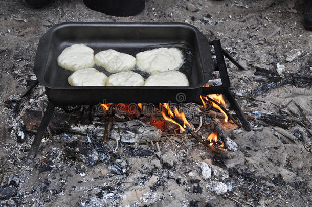 在野外条件下用火煮煎饼。
