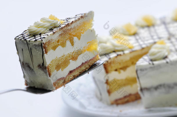 奶油蛋糕，梨和巧克力顶部的金属勺子，生日蛋糕在白色盘子，糕点，摄影为商店