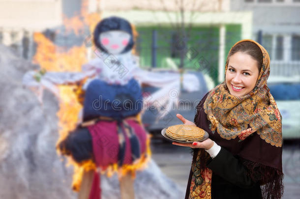 一个微笑的年轻女人在燃烧的假人马斯莱尼萨