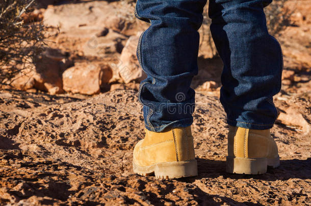 穿着黄色鞋子的男孩站在沙漠里