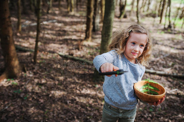 在早春森林里探索大自然的女孩。 孩子们学会热爱大自然。 教孩子们关于季节变化的知识。