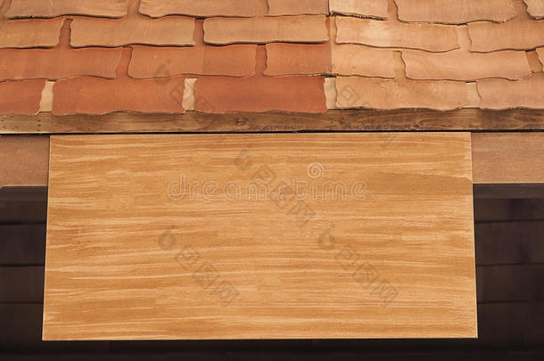 挂在木屋顶上的空白木制招牌。 木板，老式的。 木头标志板