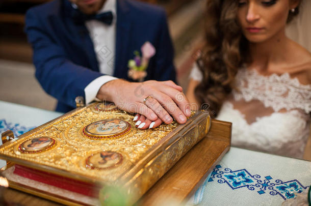 新娘和新郎在教堂用旧的金色圣经宣誓