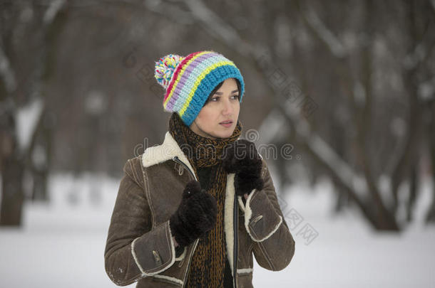 寒冷冬天公园的美女。 在户外。 飞舞的雪花。