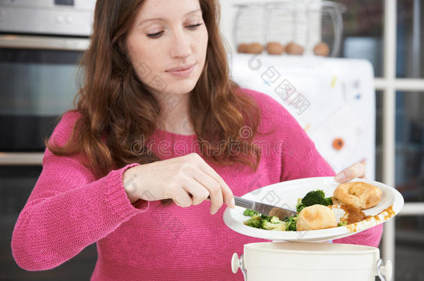 把剩饭剩饭刮进垃圾桶的女人