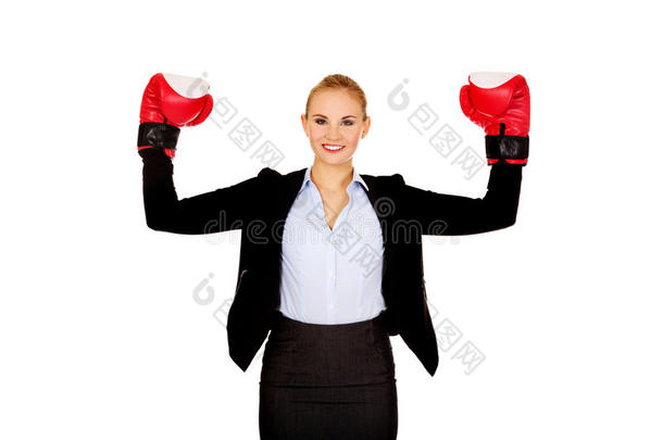 商业妇女戴着拳击手套站在胜利的姿势