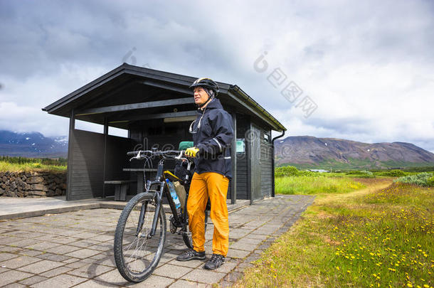 在冰岛阳光明媚的夏日，骑自行车的人骑在路上。 旅行和运动图片