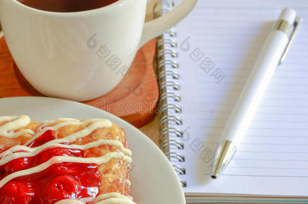 丹麦糕点，早上在木桌上放一杯热茶，一支钢笔和一个<strong>小</strong>笔记本，情人节的<strong>红心</strong>