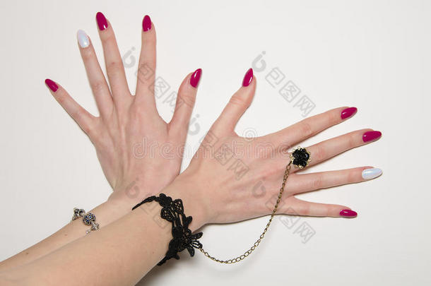 一个年轻女人的手的特写，指甲上有长长的粉红色指甲