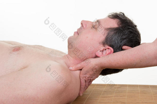 女按摩师在水疗沙龙对男人做颈部按摩。