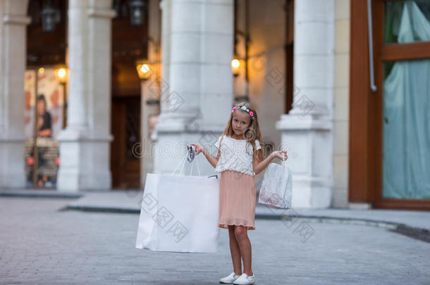 可爱的<strong>小女孩</strong>带着<strong>购物</strong>袋在巴黎户外散步