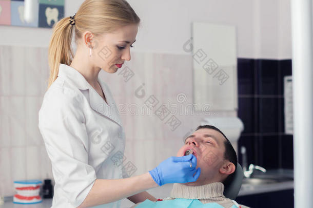 牙医和牙医办公室的人。 牙医和病人