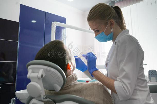 牙医和牙医办公室的人。 牙医和病人