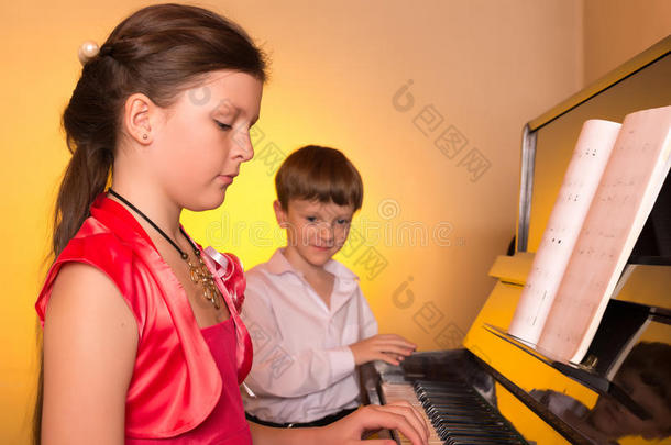 哥哥和妹妹弹钢琴。 钢琴演奏者。