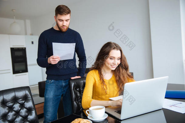 一对夫妇在家里用笔记本电脑在线支付账单
