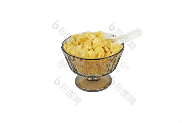 玉米片在一个棕色的传统玻璃碗里，有一个支架和一个白色的中国勺子，一半埋在玉米片里