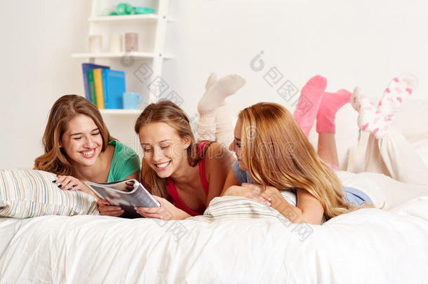 朋友或十几岁的女孩在家看杂志