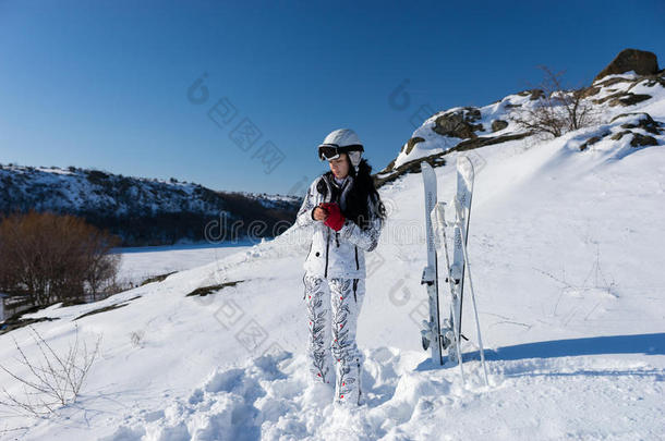 女滑雪者在山坡上戴上红色手套