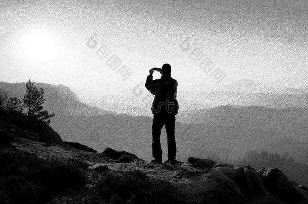 <strong>黑白</strong>虚线复古素描。 徒步旅行者正在岩石的顶峰上用智能<strong>手机</strong>拍照