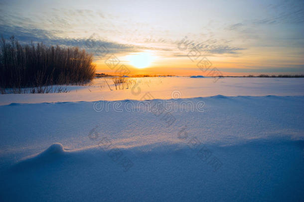 冬天日落时阳光明媚，大雪纷飞。