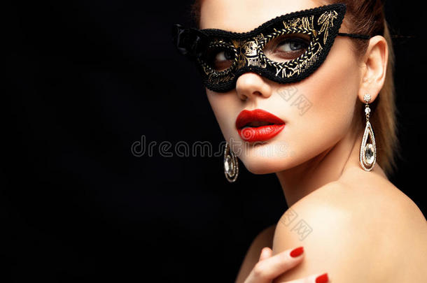 美女模特戴着威尼斯化妆舞会嘉年华面具在派对上被隔离在黑色背景上。 圣诞节和新的