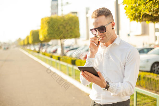 手里拿着手机和平板电脑的商人