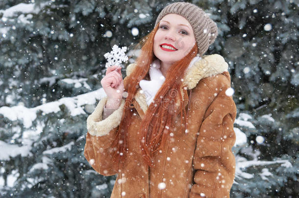 冬季户外，下雪天气，女孩肖像，展示大雪花玩具。