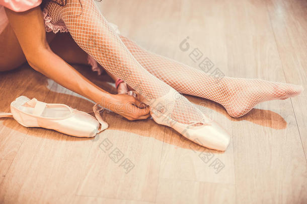 一个芭蕾舞演员在演播室里脱下芭蕾<strong>舞鞋</strong>的特写镜头