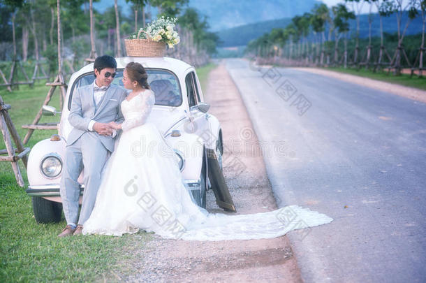 亚洲新婚夫妇在旧车