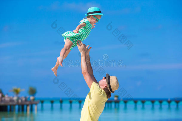 快乐的父亲和他可爱的小<strong>女儿</strong>在热带海滩玩得很开心