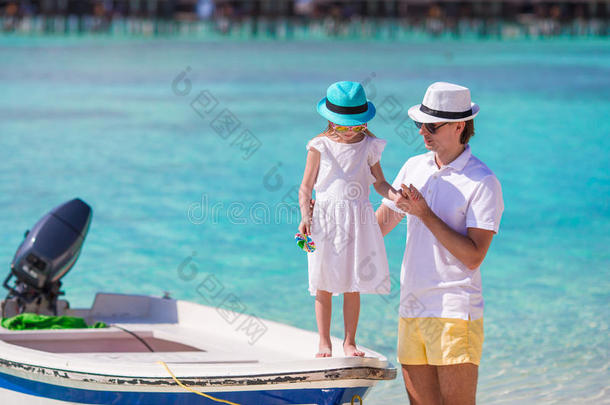 快乐的父亲和他可爱的小女儿在热带海滩玩得很开心