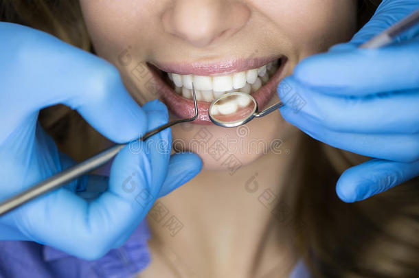 <strong>牙医</strong>在<strong>牙医</strong>身上检查病人的牙齿。