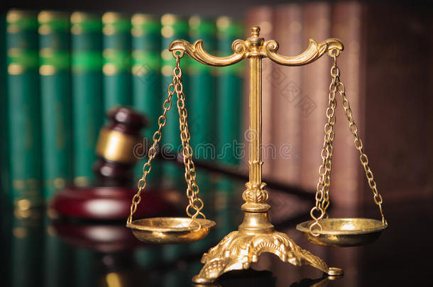 法官的木槌和法律书面前的金色鳞片