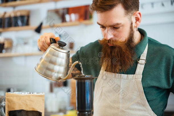 咖啡师把水倒在咖啡地上，用过滤器过滤