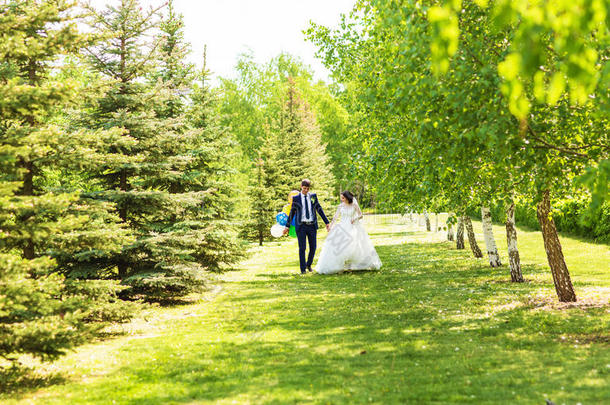 婚礼当天新娘和新郎在春天的大自然中散步。 <strong>新婚</strong>夫妇，幸福的<strong>新婚</strong>女人和男人拥抱