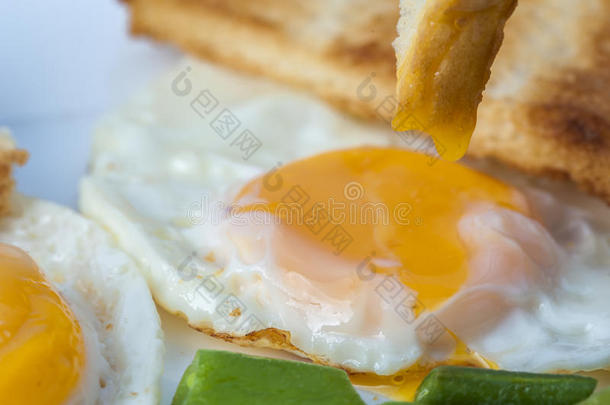 把<strong>煎鸡蛋</strong>、青豆和一片吐司放在白色盘子里。 英式<strong>早餐</strong>。