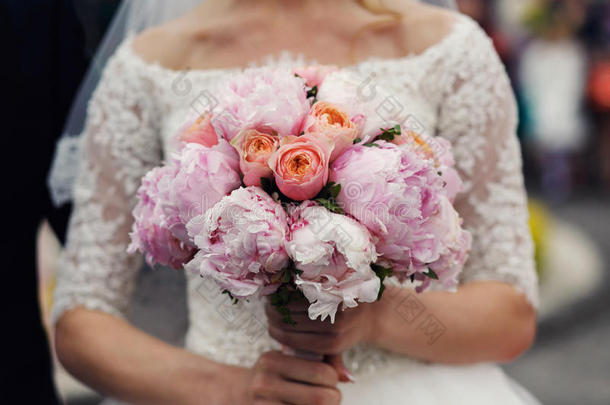 优雅时尚的新娘穿着<strong>复古婚纱</strong>和玫瑰花束