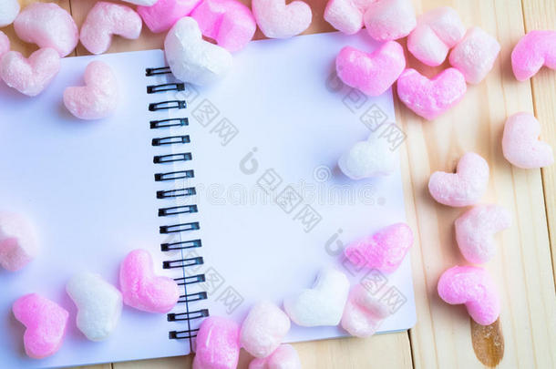 空白的白色画框与粉红色的心包围笔记本