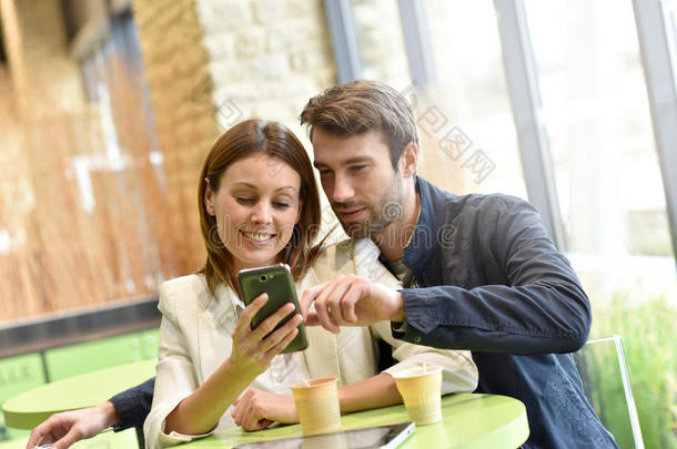 一对夫妇坐在咖啡店的网上冲浪