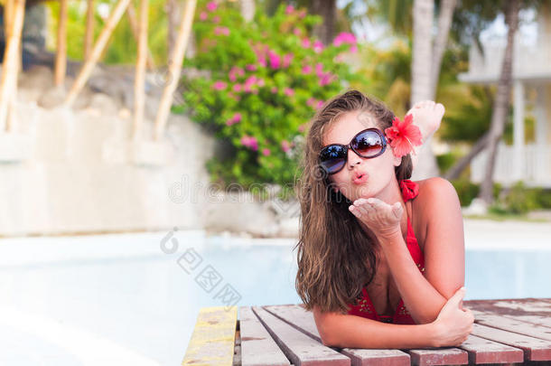 美丽的长发女人享受着一天在泳池边吹着空气的吻