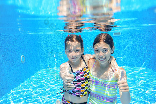 孩子们在水下游泳池游泳，快乐的活跃女孩在水下玩得很开心