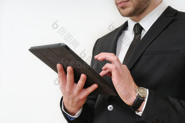 商人身侧穿着黑色西装，拿着白色的平板电脑