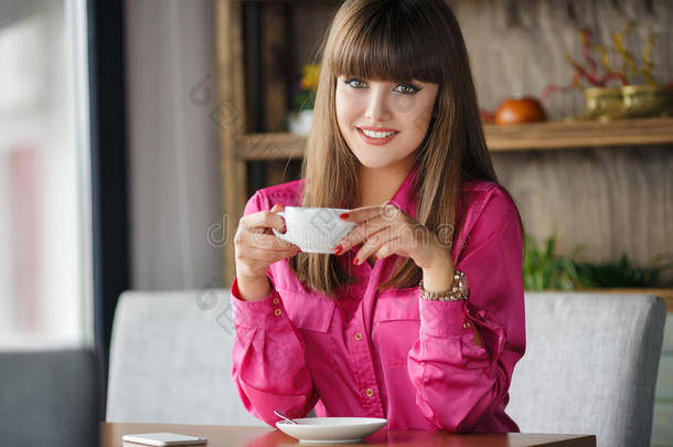 一个女孩在咖啡馆的桌子上<strong>喝了</strong>一杯热茶